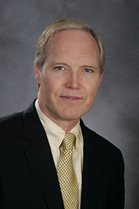 Patrick Reynolds wears a suit with monochromatic shirt and tie in shades of yellow.