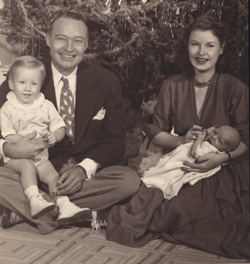 Dick and Marianne sit holding young Michael and baby Patrick Reynolds.