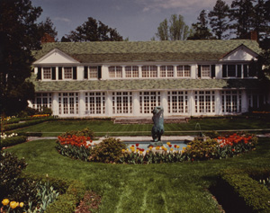 The Reynolda estate large English-style mansion with two stories and a large fountain.